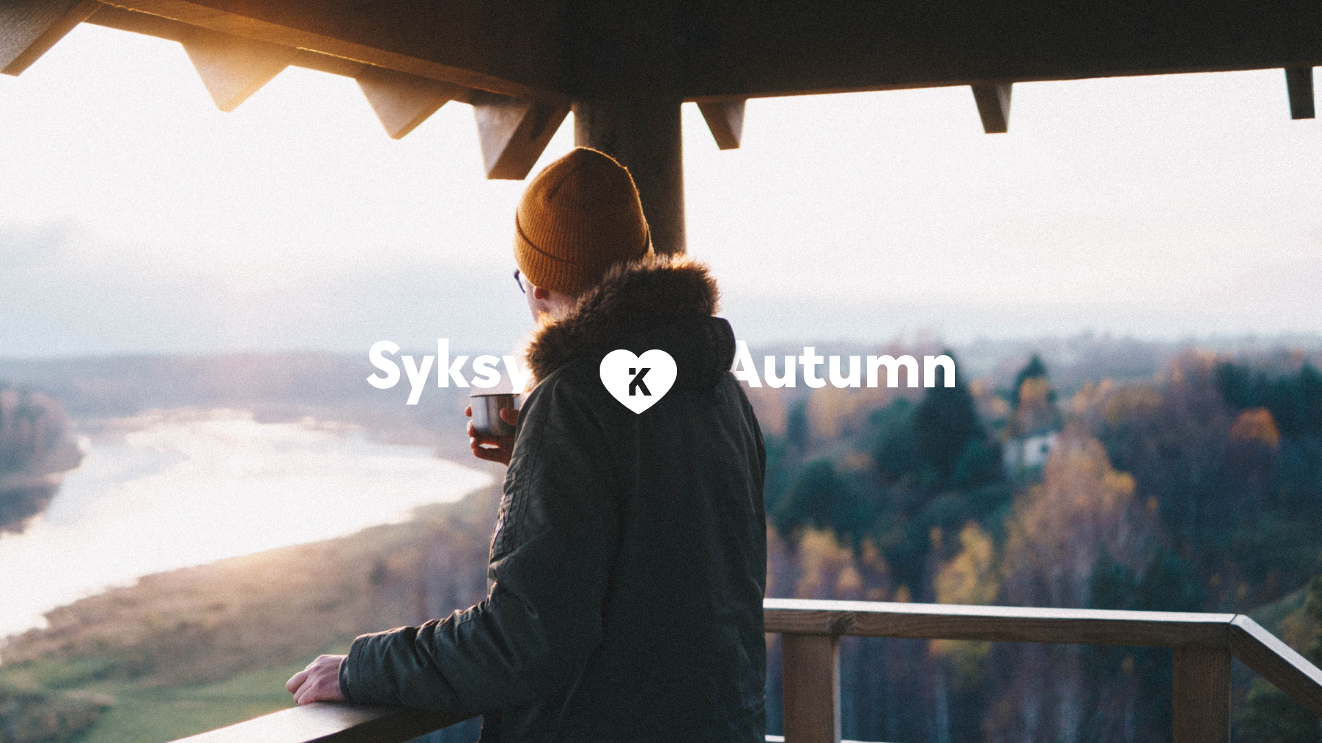 The man is standing and looking out to scenary with coffee in his hands. The picture says Syksy, Autumn